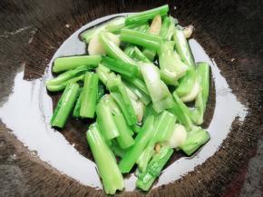 锅里油热放入蒜头煎一下再放入春菜头炒