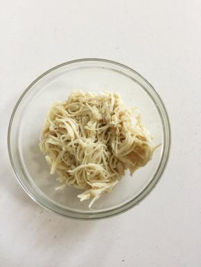 金针菇捞出挤干水分放入容器中。