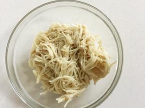 金针菇捞出挤干水分放入容器中。