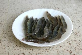 明虾洗净剪去虾须虾脚，虾背剪开挑去沙线，虾腹部剪两刀，烤的时候不会弯曲起来