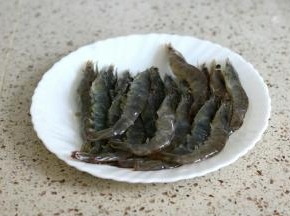 明虾洗净剪去虾须虾脚，虾背剪开挑去沙线，虾腹部剪两刀，烤的时候不会弯曲起来