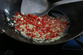 锅里倒入稍微多一些油，放入姜末和辣椒末炒出香味