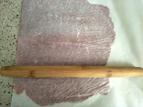 撕一块油纸(烤盘的2倍)，把肉均匀的铺在油纸上，多余的油纸盖在面上，用擀面杖来回擀紧实，越薄越好，我用的28厘米的金盘，分成两次烤