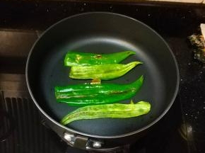 不粘锅小火放入尖椒，烧至软熟