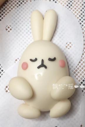 现在来做身体部分，大面团中切出40克一个的4个面团，分别排气揉搓滚圆后，整成鸡蛋状，放在馒头纸上。