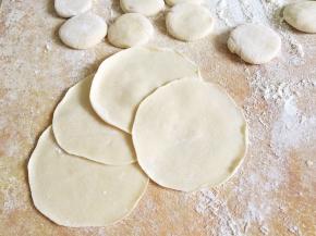 压扁后擀成中间厚边缘薄的面皮