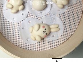 分出42克白面团排气揉搓，来做耳朵和四肢，两个耳朵分别2.5克一只，搓成长水滴，置于鸡蛋状面团顶端稍稍压住一点，两个前腿分别为2克，后腿1.5克，搓成水滴按扁，抹一点点牛奶分别粘在身体相应部位。