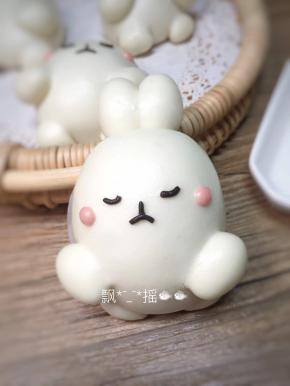 黑色面团用手指肚搓成细面条，用牙签截取，做兔子的表情，搓两个绿豆大小的粉色面团，揉圆后粘于眼睛两侧按扁。可爱的兔子完成了！多出来的面团可以再做一只小点的兔子，如果怕麻烦就直接揉成圆。