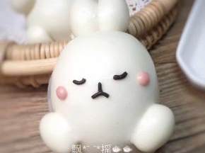 黑色面团用手指肚搓成细面条，用牙签截取，做兔子的表情，搓两个绿豆大小的粉色面团，揉圆后粘于眼睛两侧按扁。可爱的兔子完成了！多出来的面团可以再做一只小点的兔子，如果怕麻烦就直接揉成圆。