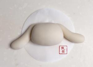 分别切出两个3克的白面团，搓成长水滴后置于梯形两侧