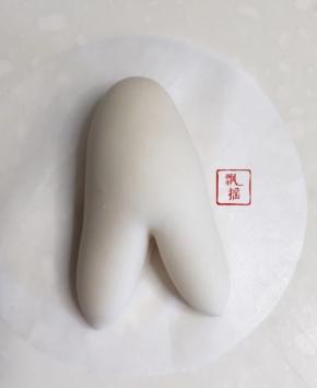 20克白面团排气揉搓滚圆后搓成瘦长椭圆作为身体，一端中间切一刀。