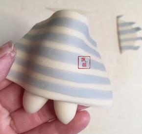 身体抹一点点牛奶，条纹面片切去两头，包住身体，轻轻按压使更加贴得紧密。