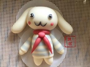 组装，身体顶端抹少许牛奶，粘合红圆圈，倒V置于胸前，搓一颗黄豆大小的红面团作为领结，抹少许牛奶粘合，头部和身体粘合，蓝色面团搓两颗绿豆大小，粘合在头部两侧，黑色面团搓两个比蓝色稍微小点的圆球，抹牛奶粘上去，再搓一丁点白面团粘在黑眼珠上，黑色面团搓细做出嘴巴，粘上腮红。