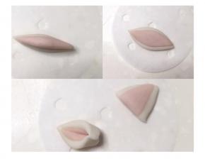 2克白面团和1克粉色面团搓成梭状，叠加后用擀面杖擀薄，对半切开两端捏牢，耳朵做好了