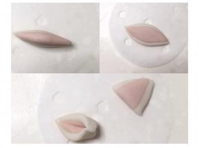 2克白面团和1克粉色面团搓成梭状，叠加后用擀面杖擀薄，对半切开两端捏牢，耳朵做好了