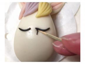 再搓更加细黑色面条，用牙签辅助粘合在眼线下方，用牙签轻轻压一压，每边粘大概6根睫毛