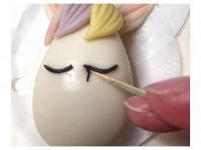 再搓更加细黑色面条，用牙签辅助粘合在眼线下方，用牙签轻轻压一压，每边粘大概6根睫毛