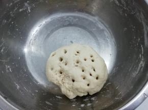 把面粉放入盆中，加入酵母，再慢慢加入水和成面团，在上面用筷子扎几个眼，这样比较快