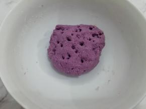 紫薯蒸好以后，用勺子压成泥，然后和面粉、酵母放在一起混合均匀，再加入水紫薯面团，放在温暖处发酵