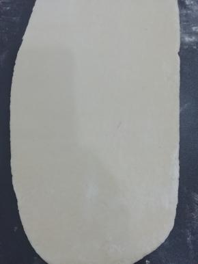 饧好的面团用擀面杖擀成长方形，紫薯面也同样擀成长方形