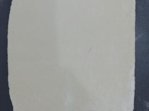 饧好的面团用擀面杖擀成长方形，紫薯面也同样擀成长方形