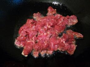 锅里多加一点油，下蒜泥炒香，加入腌制好的牛肉入锅