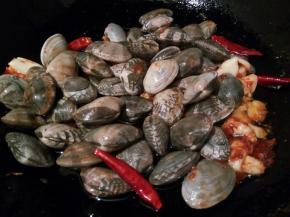 将控好水的花蛤倒入翻炒，花蛤提前放清水中，加一勺盐让花蛤吐沙，也可在买花蛤时让商贩给点海水，花蛤用清水清洗几遍，再将带回的海水养花蛤，让其来吐沙