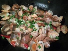 花蛤它会有水分出来，咱们收汁时不要全部都收了，汤汁也要留一点，沾着汤汁才更加美味，看汤汁差不多，加一点鸡粉，撒点葱花提香，就可以出锅享用