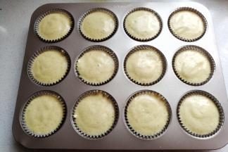 再把拌好的蛋糊倒入纸杯中约八分满，轻轻震荡几下使其表面平整