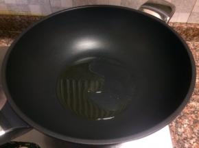 热锅倒油烧至八成热。