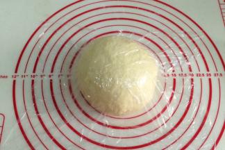 将面团取出排气滚圆，盖好保鲜膜松弛15分钟。