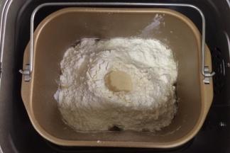 除黄油以外的面包材料都放入面包机内（先液体后粉类的顺序），在面粉中间挖个洞，把酵母粉倒入，启动和面程序。