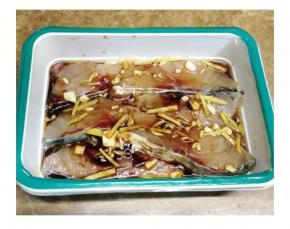 将鲩鱼腩洗净，沥干水分后加入油、姜丝、蒜片、酱油、料酒、盐、蚝油拌匀放入冰箱腌一晚
