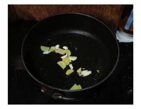 不粘锅倒入油，放入姜片和蒜头片爆香