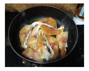 蒜、姜片爆香后，放入腌制好的鱼腩，慢火将两面煎至肉变白色
