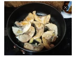 两面煎好后把腌制鱼腩酱汁倒入锅里，再放少许料酒、白糖调味