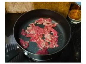 不粘锅下少许油放入牛肉片煸炒