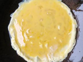 锅里油热放入鸡蛋煎