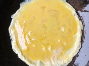 锅里油热放入鸡蛋煎