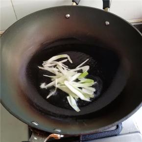 五成热时将一半葱段放入爆香。