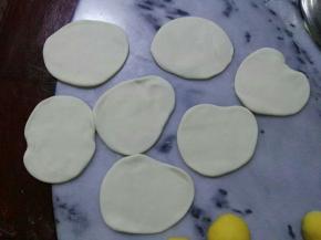 白色的面团随意擀成4mm左右的面片。
另外两个小的南瓜，直接搓圆，按扁，抹水粘到白面片上。
**所有造型好的懒蛋蛋都抹点水，沾贴到白面片上。