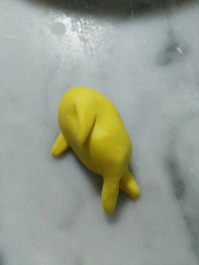 把剪开的地方，稍微拉长整一下形，成手脚。脚要交叉放，如图。