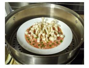 洒入葱花，将白玉菇肉饼放入蒸锅里中火15分钟至熟