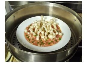 洒入葱花，将白玉菇肉饼放入蒸锅里中火15分钟至熟