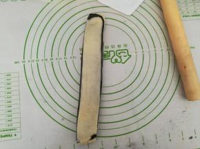 将其中一半的白色部分朝上叠到另一半上，继续擀薄。