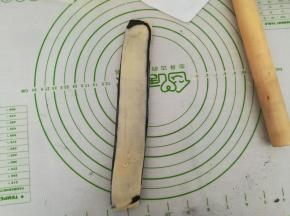 将其中一半的白色部分朝上叠到另一半上，继续擀薄。