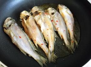 平底锅或者电饼铛内放油烧热，放入黄花鱼煎