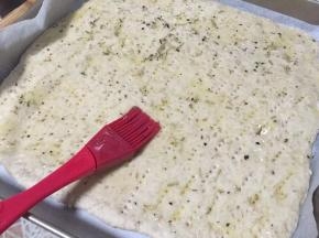 将浸泡好的小番茄迷迭香橄榄油刷与薄饼上
