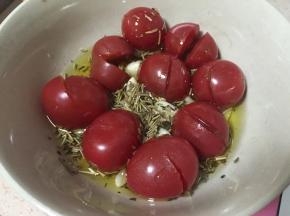 做面包前我们准备小碗倒入25克橄榄油，将小番茄划一刀口子，加入蒜瓣、罗勒碎、迷迭香碎 浸泡半小时以上