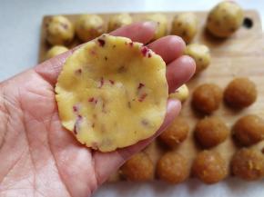 取一份酥皮面团用手心压扁，尽量使其中间厚四周薄点